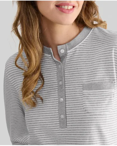 Woman wearing long grey striped pyjamas with a turtleneck top and long grey melange trousers