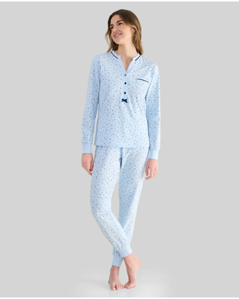 Woman wearing long sky blue winter pyjamas with a floral print, button-up collar and pocket