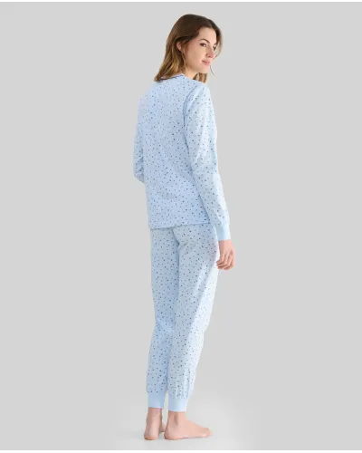 Woman wearing long sky blue winter pyjamas with a floral print, button-up collar and pocket