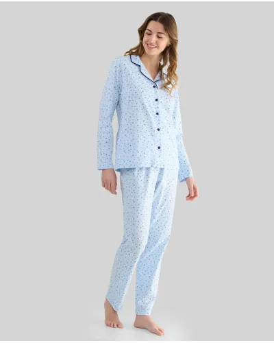 Woman wearing light blue long-sleeved pyjamas with buttons, small floral print and contrasting piping