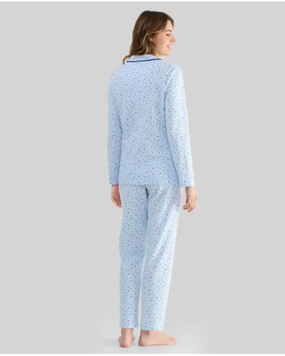 Woman wearing light blue long-sleeved pyjamas with buttons, small floral print and contrasting piping