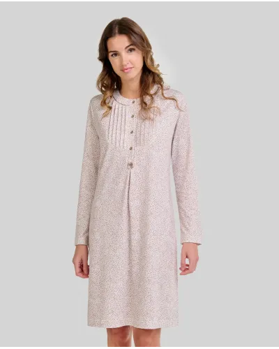 Woman wearing a long-sleeved, knee-length nightdress with a camel-coloured floral print and front buttons.