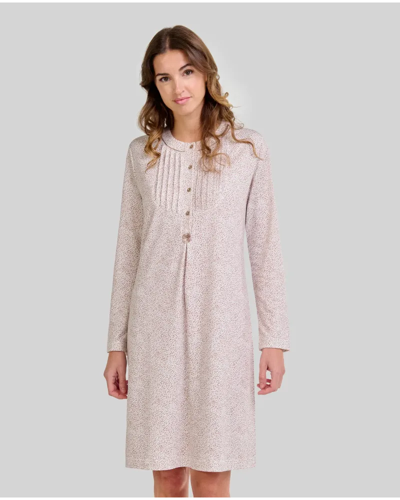 Woman wearing a long-sleeved, knee-length nightdress with a camel-coloured floral print and front buttons.
