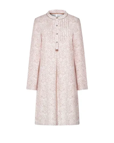 Woman wearing a long-sleeved, knee-length nightdress with a camel-coloured floral print and front buttons.