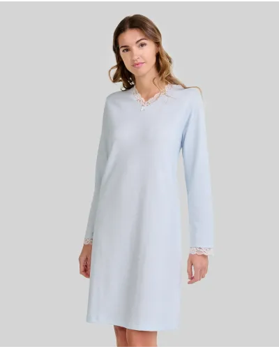 Woman wearing a classic long-sleeved sky blue chemise nightdress with a V-neckline and lace trim.