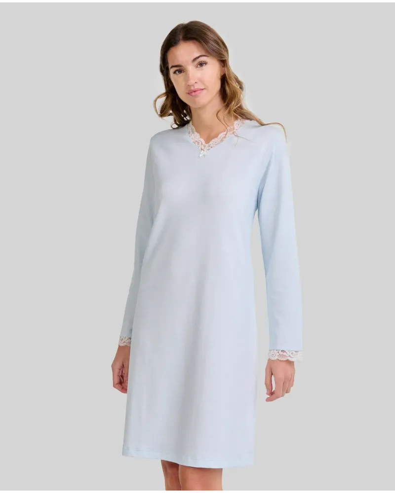 Woman wearing a classic long-sleeved sky blue chemise nightdress with a V-neckline and lace trim.
