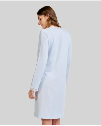 Woman wearing a classic long-sleeved sky blue chemise nightdress with a V-neckline and lace trim.