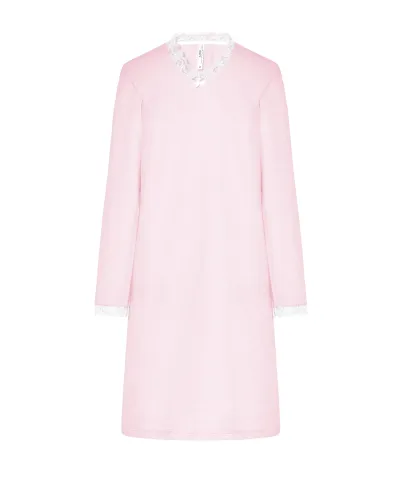 Woman wearing a pink long-sleeved chemise nightdress with a V-neckline and lace trim