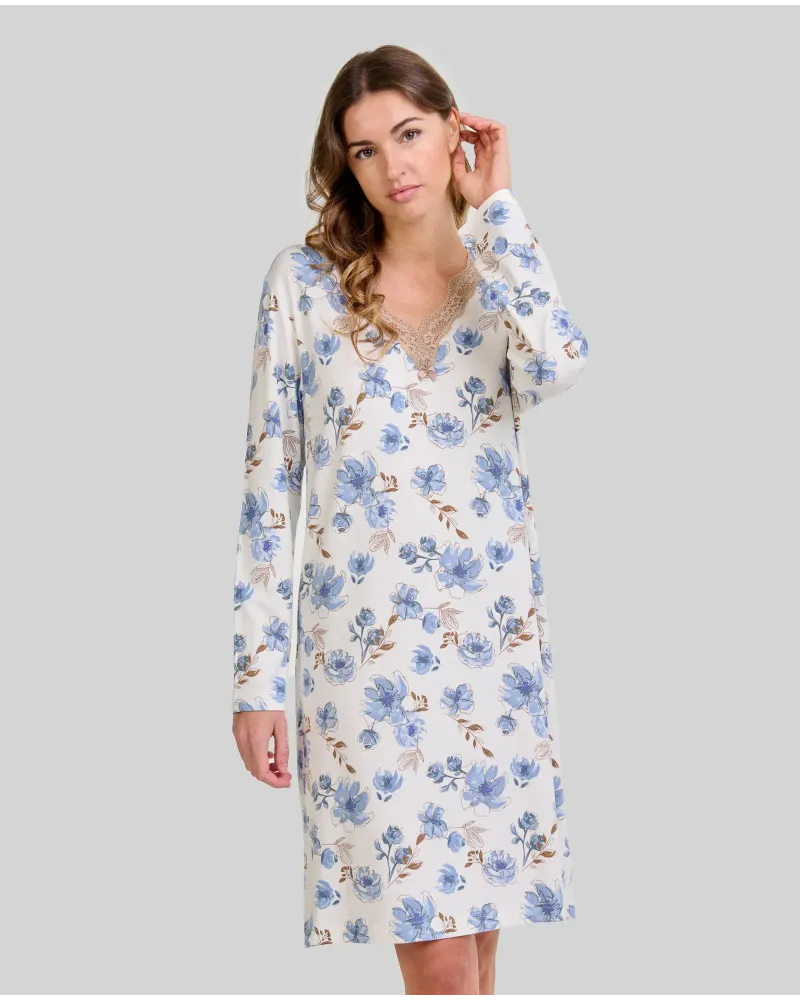 Woman wearing a long-sleeved winter nightgown with blue flowers and lace at the neckline