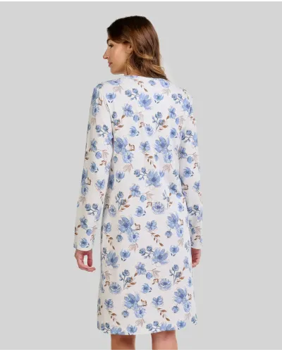 Woman wearing a long-sleeved winter nightgown with blue flowers and lace at the neckline