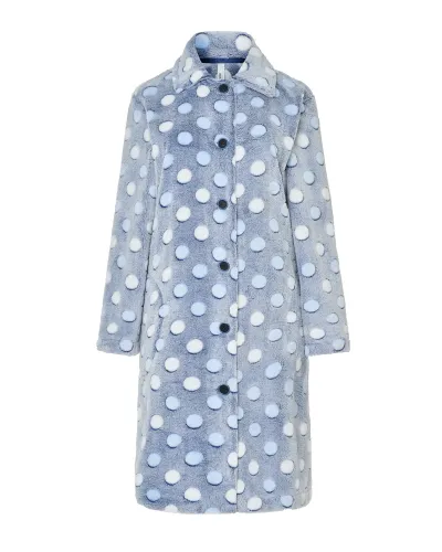 Mujer en bata celeste de lunares en relieve hasta la rodilla, manga larga y botones con bolsillos laterales.