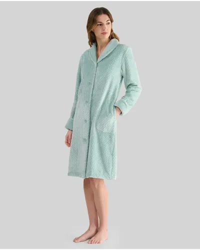 Woman wearing a long buttoned winter coat in a pleasant green jacquard fabric with pockets