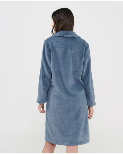 Woman wearing a long, buttoned winter coat in Pacific blue jacquard
