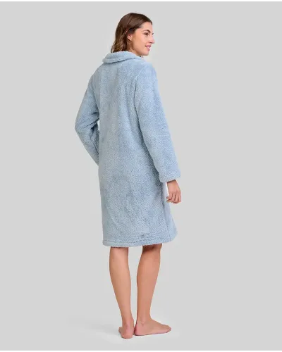 Woman wearing a steel blue buttoned terry cloth robe that reaches to the knee and has large side pockets.