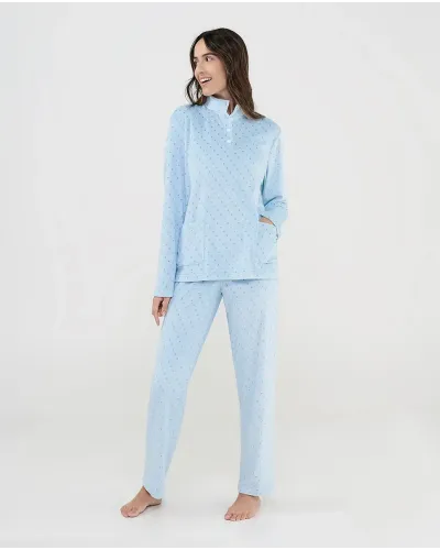 Woman wearing winter pyjamas in a tracksuit style with a light blue polka dot print and button-up collar.
