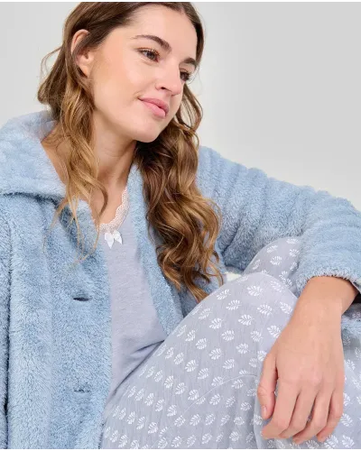 Woman wearing blue leaf-patterned pyjamas and winter dressing gown