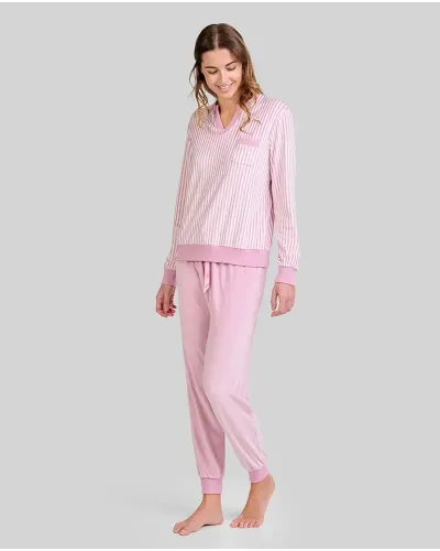 Woman wearing comfortable light pink microfleece pyjamas with a striped T-shirt and plain trousers