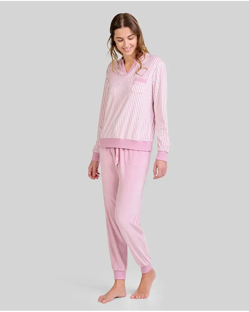 Woman wearing comfortable light pink microfleece pyjamas with a striped T-shirt and plain trousers