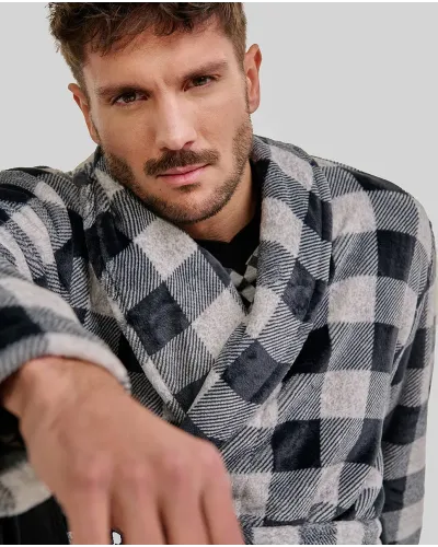 Man wearing a black and white checked winter dressing gown with a belt and pockets