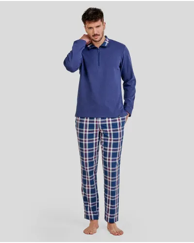 Man wearing long winter pyjamas with a blue jacket with a zip-up collar and checked trousers with pockets.