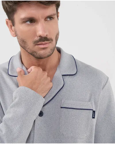 Man wearing light grey long-sleeved pyjamas with bright black trim and front buttons, ideal for sleeping.