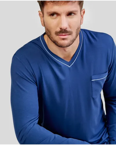 Man wearing long blue modal winter pyjamas with a V-neck and side pockets.