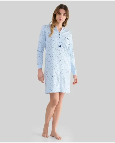 Woman wearing a light blue long-sleeved nightdress with small flowers and an open neckline with buttons and a bow