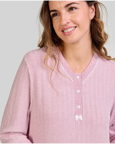 Woman wearing a long pink ribbed winter nightdress with a buttoned V-neck and bow