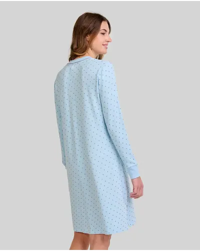 Woman wearing a light blue long-sleeved nightdress with a small polka dot pattern and pocket