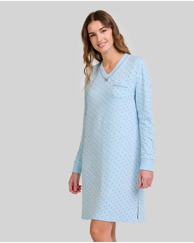 Woman wearing a light blue long-sleeved nightdress with a small polka dot pattern and pocket