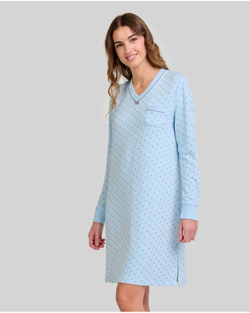 Woman wearing a light blue long-sleeved nightdress with a small polka dot pattern and pocket