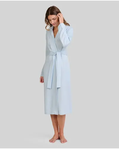 Woman wearing a long sky blue lace-up dressing gown with a tuxedo collar and piping