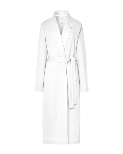 Woman wearing a long ivory lace-up dressing gown with pockets, tuxedo collar and piping