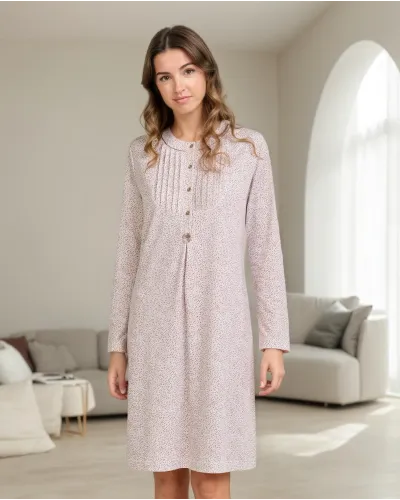 Woman wearing a long-sleeved, knee-length nightdress with a camel-coloured floral print and front buttons.