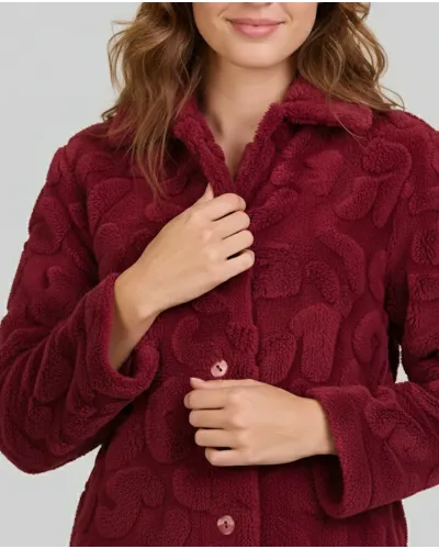 Woman wearing a long, buttoned winter coat with pockets in lovely maroon jacquard fabric