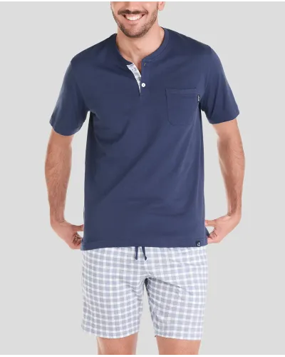man wearing navy blue short-sleeved summer pyjama top and checked shorts