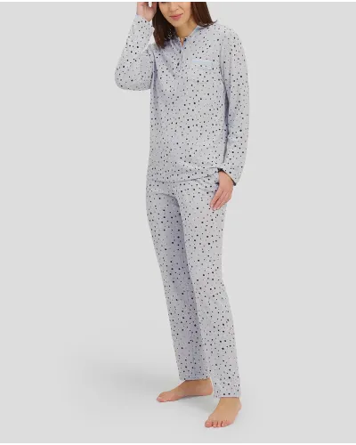 Woman with long-sleeved winter pyjamas in grey taupe with polka dot pattern