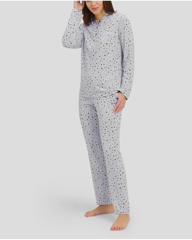 Woman with long-sleeved winter pyjamas in grey taupe with polka dot pattern