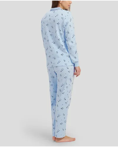 Woman in light blue long-sleeved winter pyjamas with stars and V-neck with bow decoration