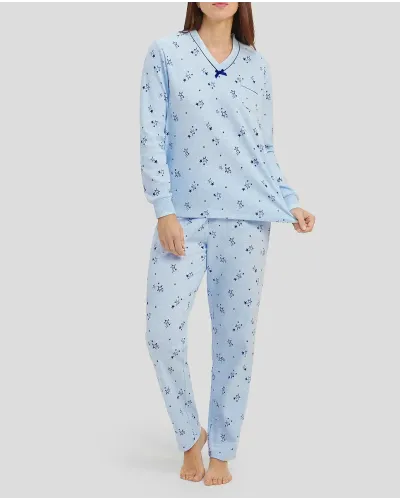 Woman in light blue long-sleeved winter pyjamas with stars and V-neck with bow decoration