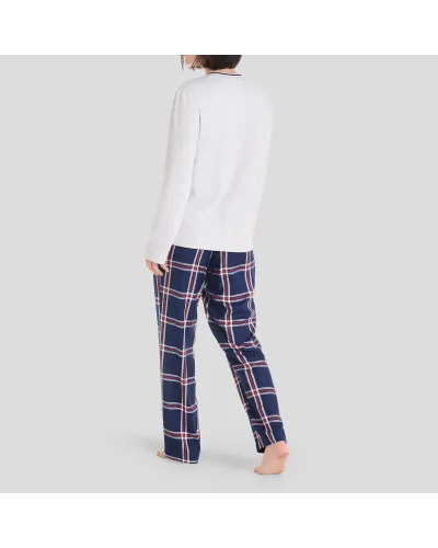 Woman in long Christmas pyjamas with plain embroidered V-neck top and matching navy checked trousers.