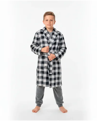 Boy wearing a black and white checked winter dressing gown over grey velvet pyjamas