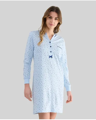 Woman wearing a light blue long-sleeved nightdress with small flowers and an open neckline with buttons and a bow