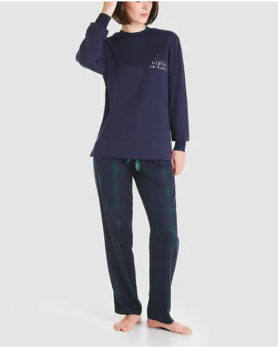 Woman in navy Christmas pyjamas and green checked trousers