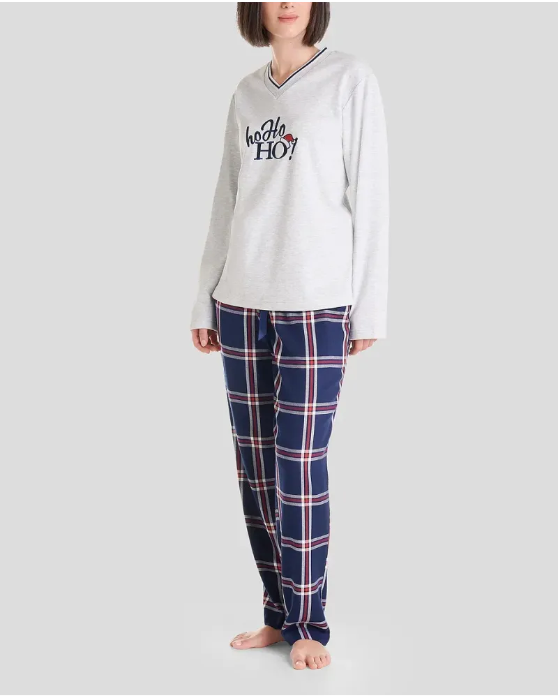Woman in long Christmas pyjamas with plain embroidered V-neck top and matching navy checked trousers.