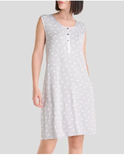 Woman in elegant grey sleeveless knee-length nightdress with subtle white feather print and open collar with silver buttons.