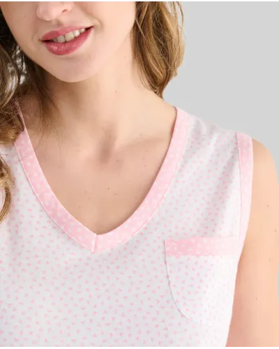 A woman with her back turned wears a light-coloured sleeveless summer camisole with delicate prints of light blue hearts.