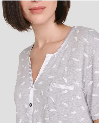 Model poses in grey summer pyjamas with long trousers and short-sleeved T-shirt with feather print.