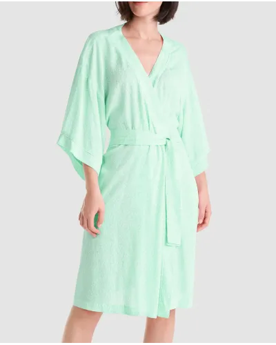 Mujer con bata corta veraniega de viscosa verde estampada a topitos, bolsillos laterales, cinturón y manga francesa