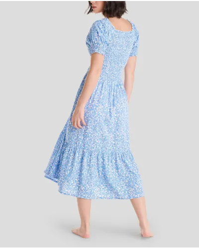 Woman in long blue flowered dress with short sleeves, honeycomb top and square neckline